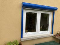 Kunststoff-Fenster in weiß mit blauem Rollladenkasten 